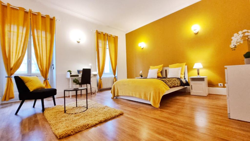 Dormitorio amarillo con cama y silla en Le Serenity - Spacieux et Confortable - Relax BNB, en Mulhouse