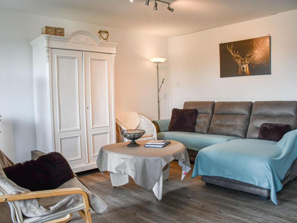 uma sala de estar com um sofá e uma mesa em Holiday apartment Owl's Nest em Tennenbronn