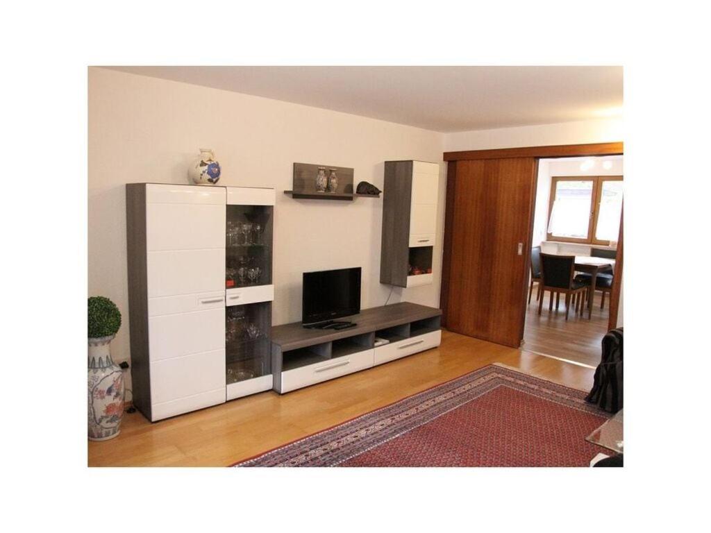 a living room with a white entertainment center with a television at Holiday apartment Schlossblick 2 in Zwingenberg