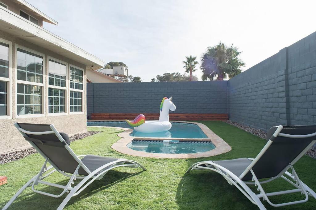 einen Hinterhof mit einem Pool mit Ente und zwei Stühlen in der Unterkunft Stunning 6BR I 4BA Luxury Haven I 31 nights min stay I in Las Vegas