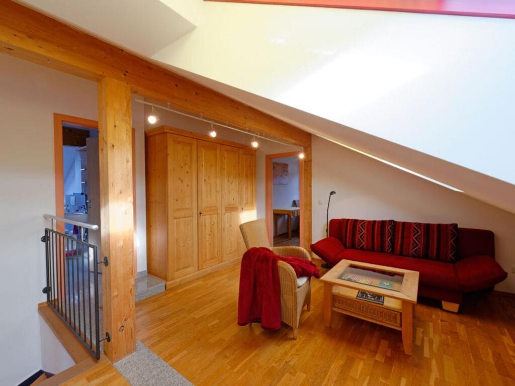 een woonkamer met een rode bank en een tafel bij Lovely apartment in Lenggries in Lenggries