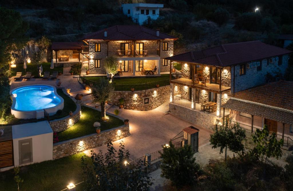 an aerial view of a house at night with a swimming pool at Lithos Villas Apollon in Sikia