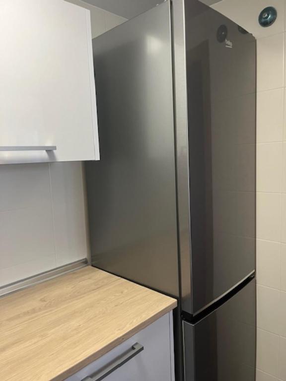 a stainless steel refrigerator in a small kitchen at Costa Reinante Foro in Barreiros
