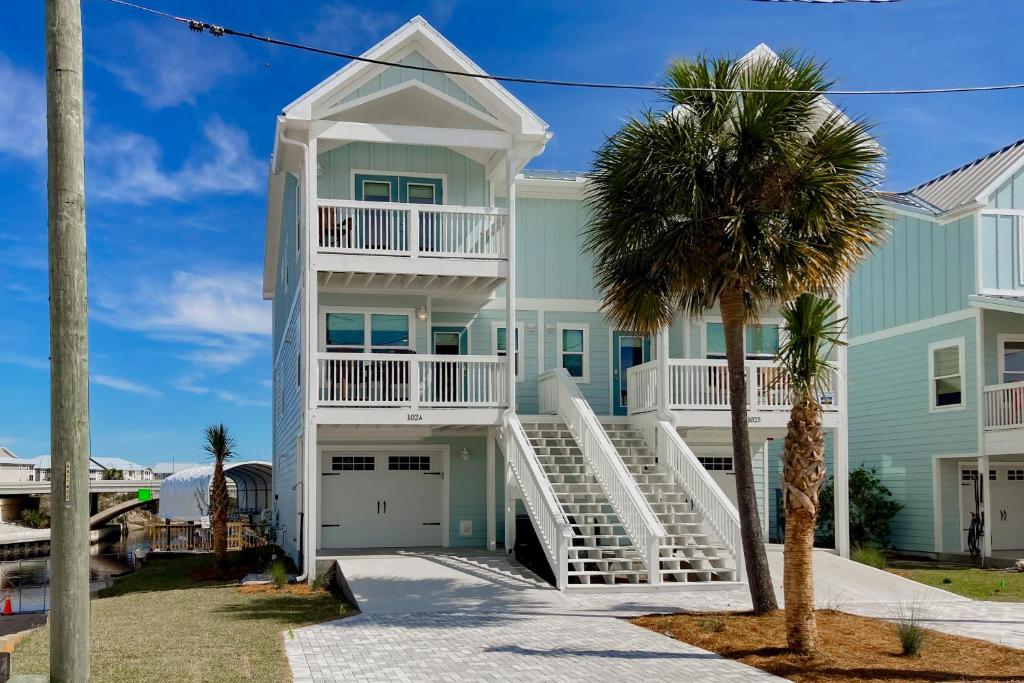 a large white house with a palm tree at Seaside Harbor Retreat in Mexico Beach