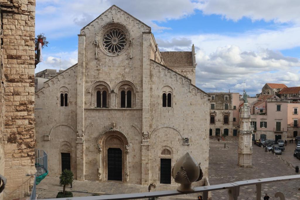 uma grande igreja de pedra com um relógio na frente em Terrazza Romanelli Suites em Bitonto