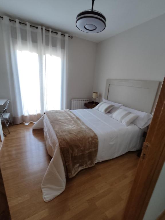 ein Schlafzimmer mit einem großen Bett und einem großen Fenster in der Unterkunft Luz de la Avenida in Tomelloso