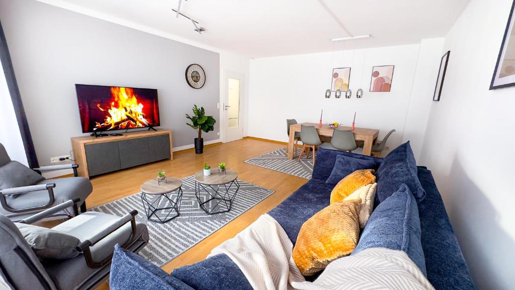 een woonkamer met een blauwe bank en een open haard bij Zentrum, 3 Zi, Tiefgarage, smart TV, WLAN, Netflix, Küche in Augsburg