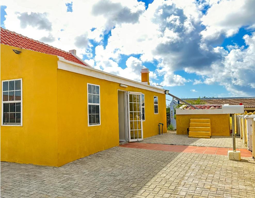 a yellow house with a brick driveway at Villa Rubia Bonaire in Kralendijk