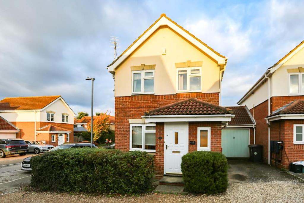 a red brick house with a white garage at Comfortable 3 bed house in Chelmsford in Chelmsford