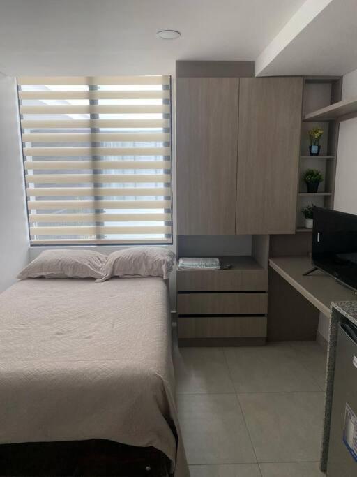 Schlafzimmer mit einem Bett, einem Schreibtisch und einem Fenster in der Unterkunft Nuevo y bonito Apartamento in Popayan