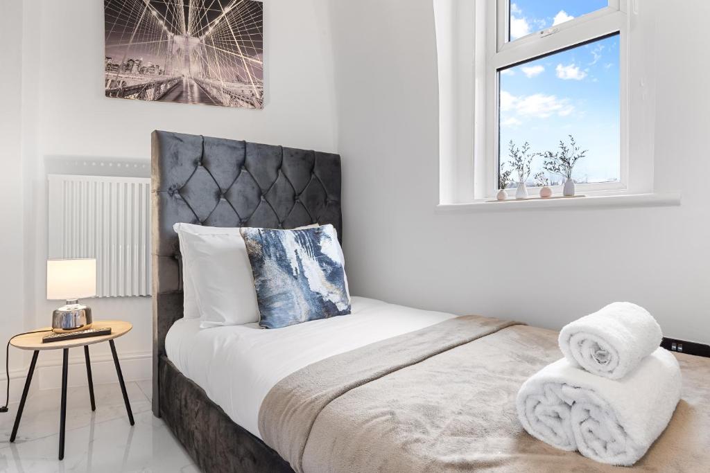 a white bedroom with a bed and a window at Cosy Studio Flat - Central London NW3 - Transport Links Euston, King Cross, Finchley Road Station in London