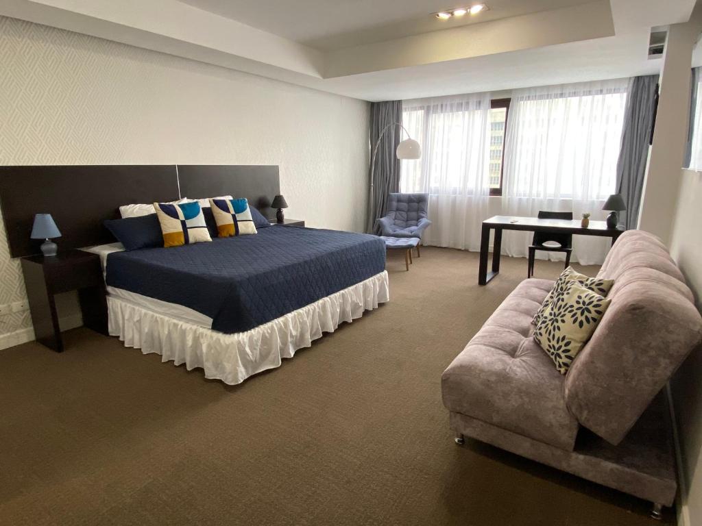 a large bedroom with a bed and a couch at Suite HotelCCT in Caracas