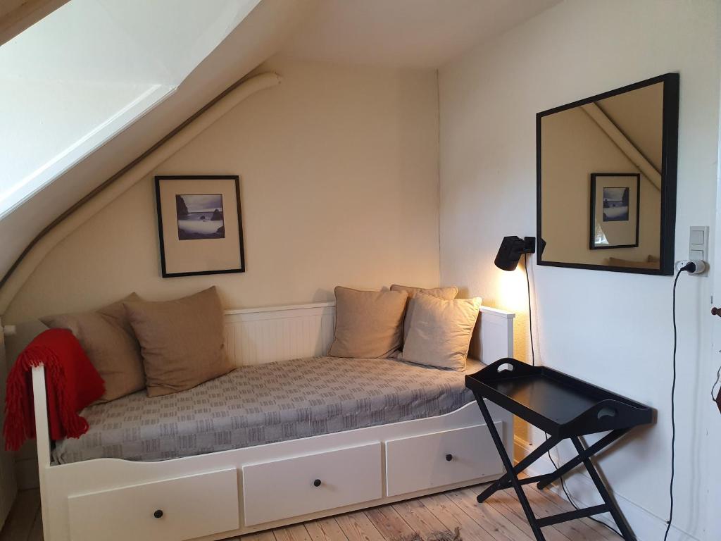 Habitación con cama debajo de las escaleras en Edelsminde Bed & Breakfast en Haslev