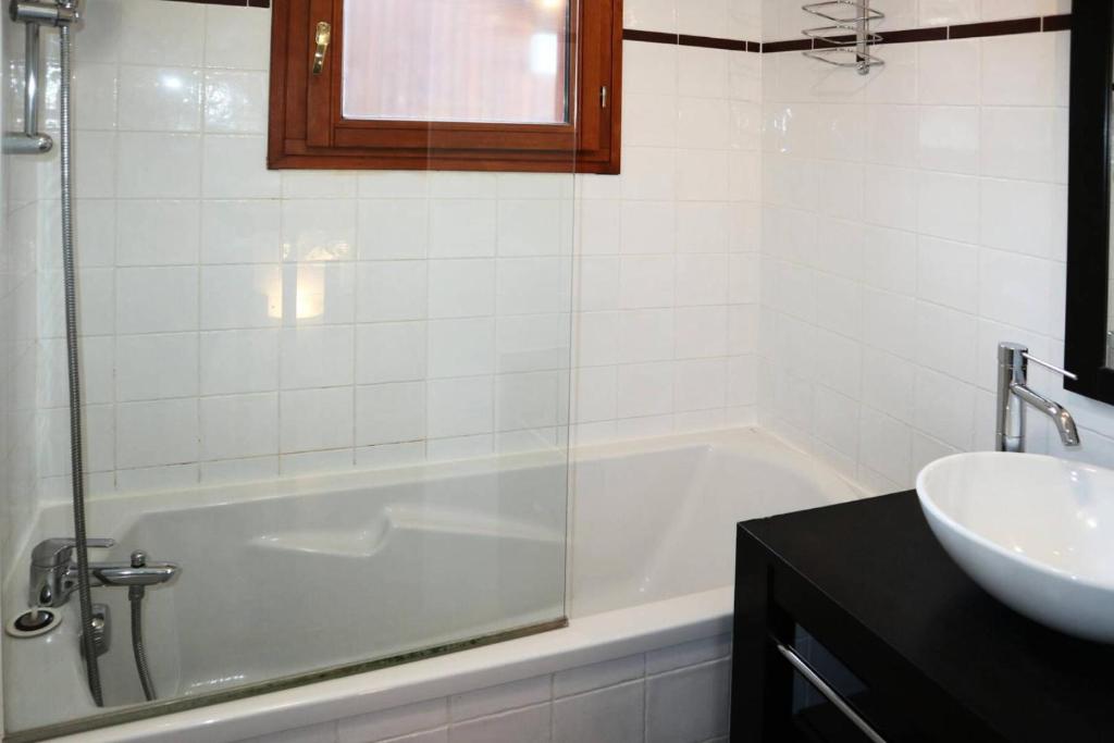 W łazience znajduje się wanna i umywalka. w obiekcie Chalet La Combe D Or - Chalet mitoyen en résidence de standing MAE-3884 w mieście Le Mélézet