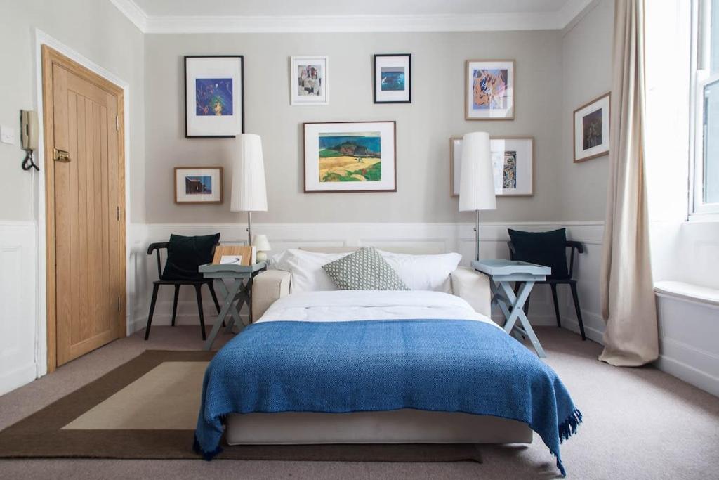 a bedroom with a bed with a blue blanket at Traditional Studio Apartment in Fitzrovia near Oxford Street in London