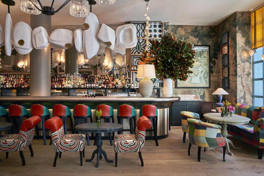 a restaurant with red chairs and a bar at Warren Street Hotel in New York