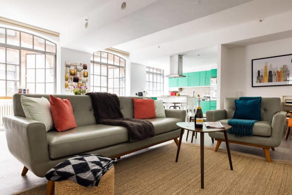 a living room with a couch and a table at Central Soho Warehouse Loft with Concierge in London