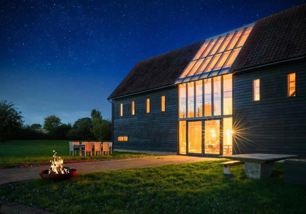 a barn at night with the lights on at Grand Suffolk Barn Conversion in Chelsworth