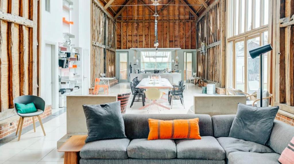 a living room with a couch and a dining room at Grand Suffolk Barn Conversion in Chelsworth