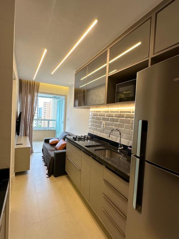 uma cozinha com um frigorífico e um sofá num quarto em Apartamento lindo e completo em Salvador em Salvador