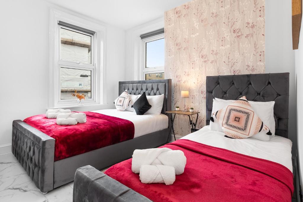 a bedroom with two beds and a red blanket at Stylish One Bedroom Flat - Sleeps 4 - Near Primrose Hill, Lord's Cricket Ground, Camden Market - Finchley Road Station - Central London NW3 in London