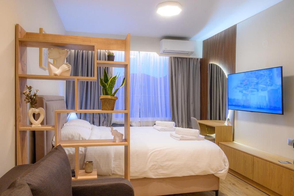 a hotel room with a bed and a tv at CityZen_io in Ioannina