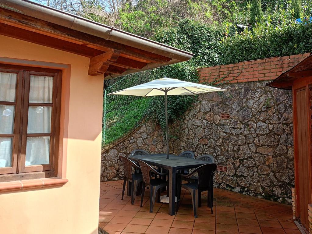 una mesa y sillas con una sombrilla en el patio en Per chi ama mare e montagna!, en Camaiore