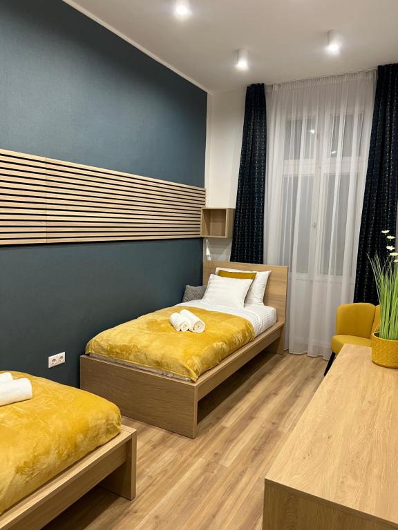 1 dormitorio con 2 camas y pared azul en DS36 Budapest-Belvárosi lakás, en Budapest