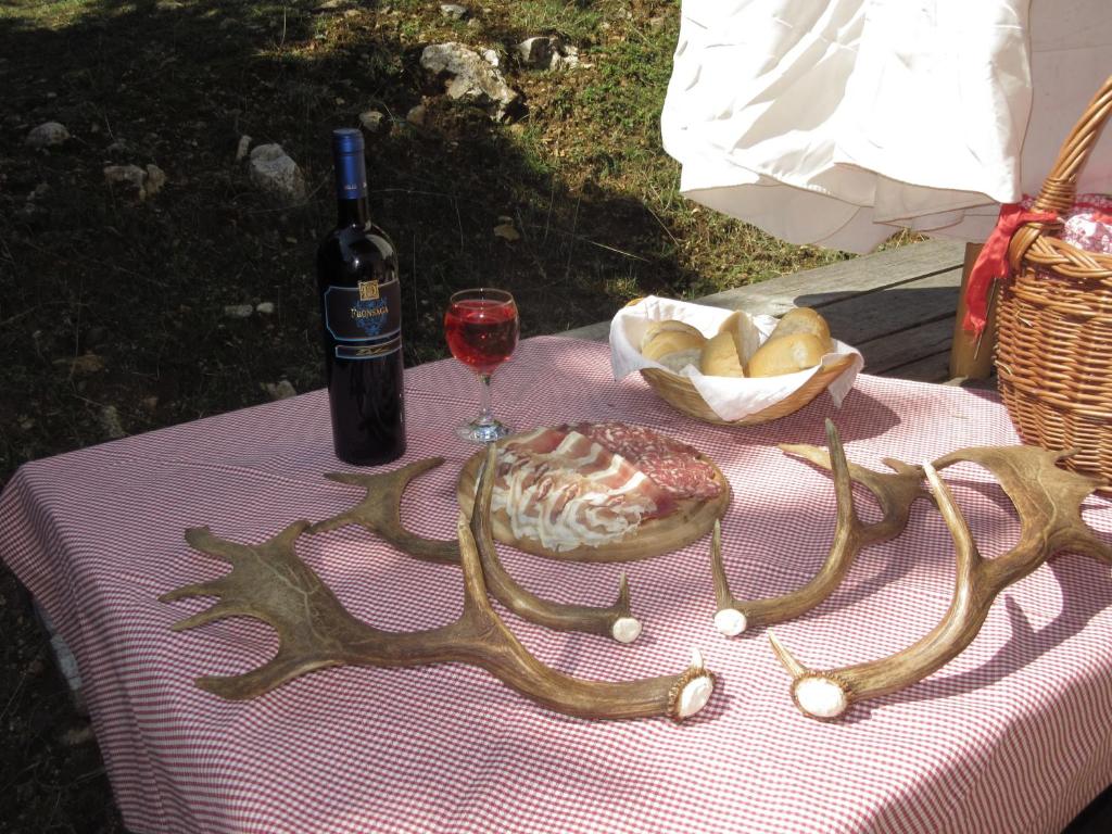 a table with a bottle of wine and a glass at Agriturismo AGRIMON in Sabbio Chiese