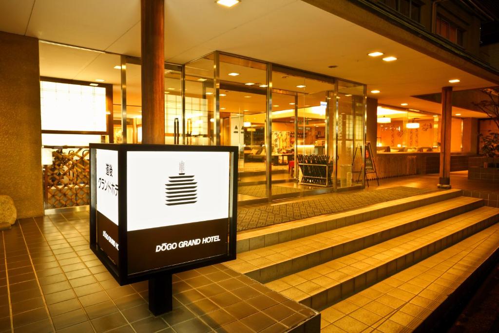 a building with a sign in front of a store at Dogo Grand Hotel in Matsuyama