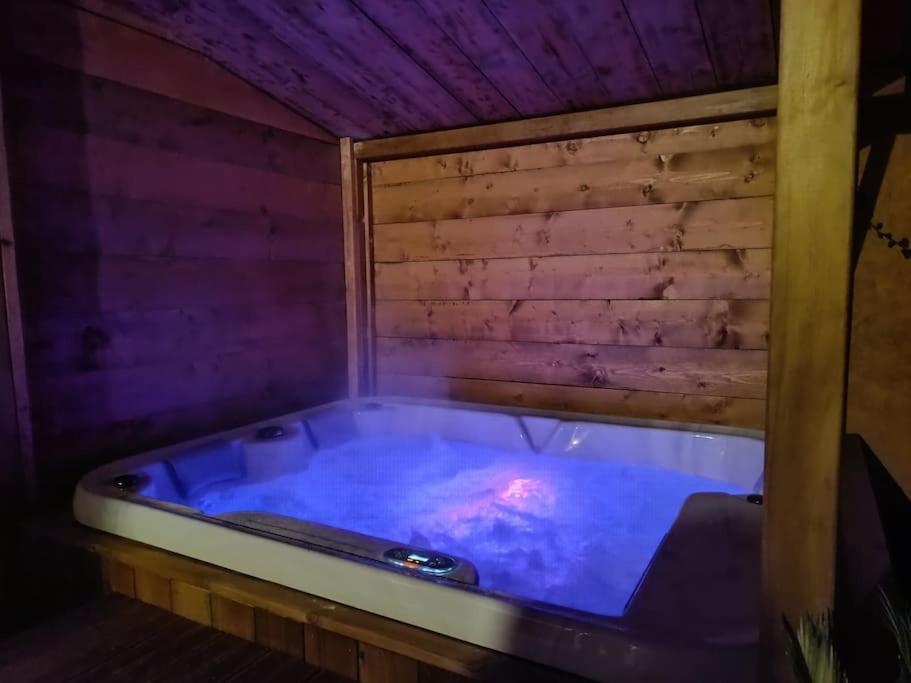 - un bain à remous dans une chambre dotée d'un mur en bois dans l'établissement Studio mezzanine, jardin et jacuzzi, à Lorgues