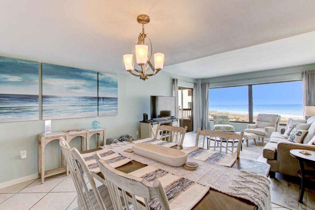 a dining room with a table and chairs and a living room at B162 Surf & Racquet - 1BR at Amelia Surf & Racquet Club next to The Ritz! in Amelia Island