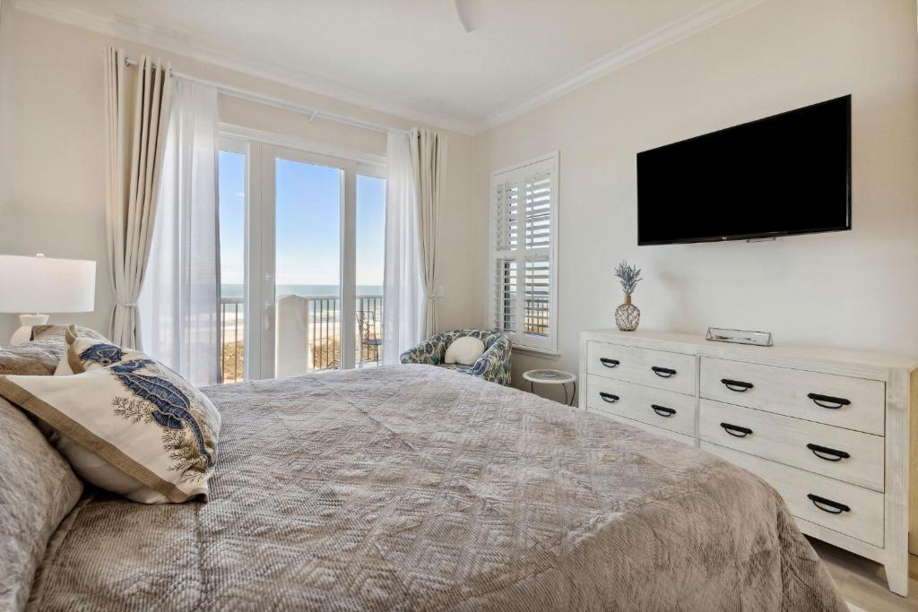 a bedroom with a large bed with a television on the wall at 58 Ocean Place - Luxury 2BR 2Ba oceanfront condo right next door to the Ritz Carlton in Fernandina Beach