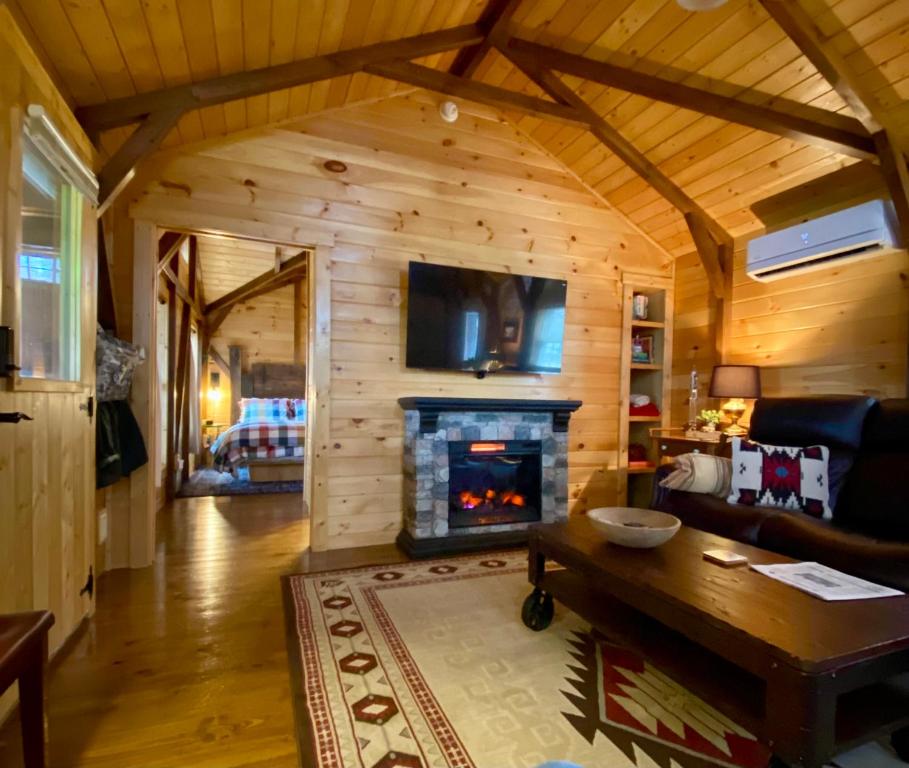 Cabaña de madera con sala de estar con chimenea en Disarmingly Cozy 1BR Cabin, en Henderson