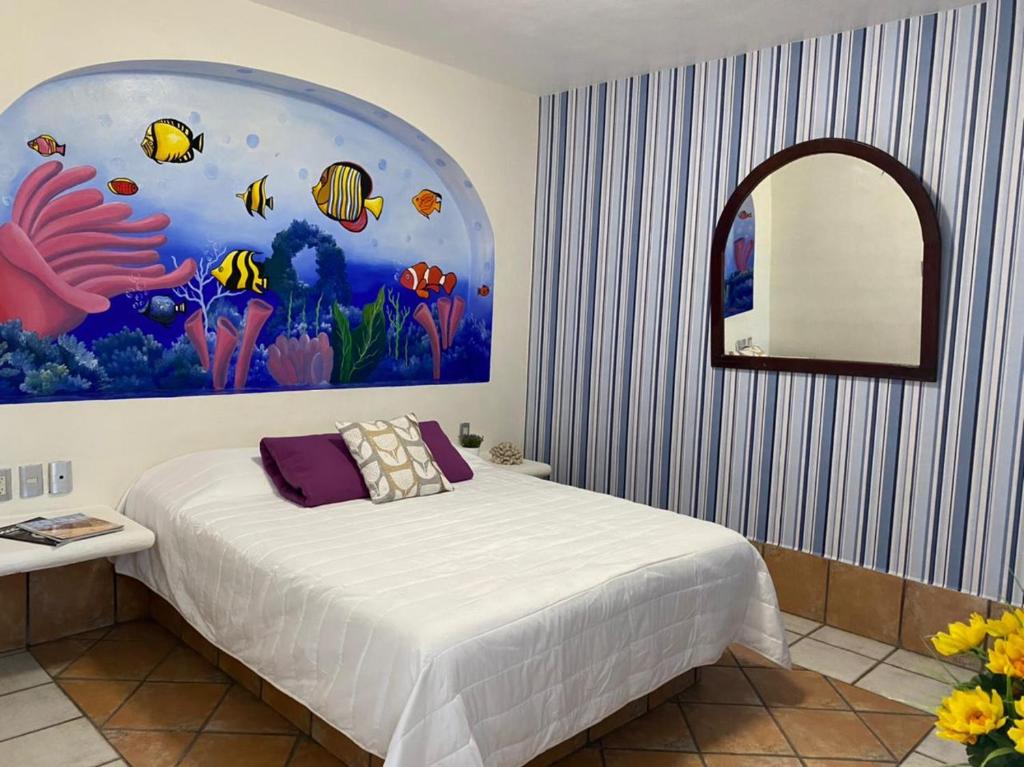 a bedroom with a bed with a painting on the wall at Hotel Yauco in Rosario