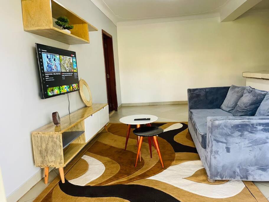 a living room with a couch and a table at Serenity in style in Kampala