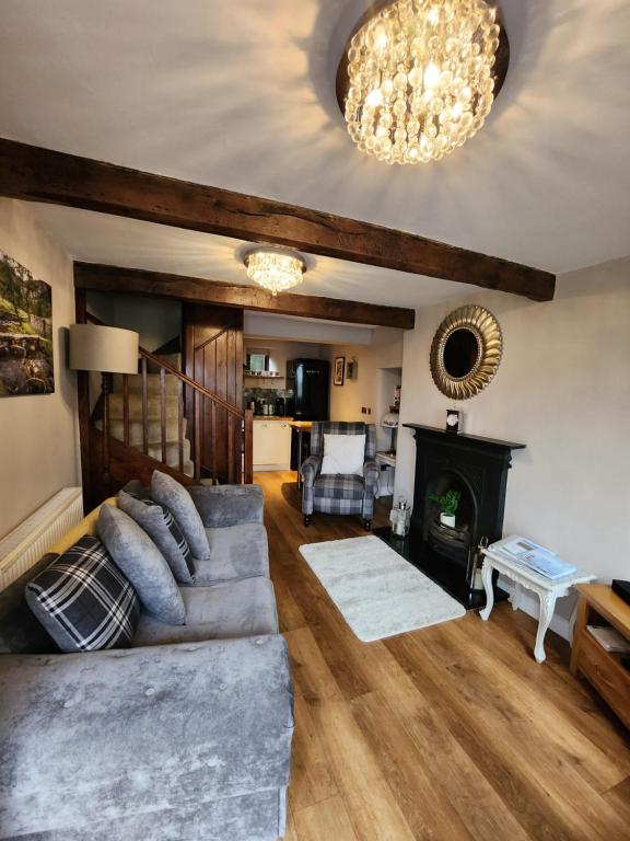uma sala de estar com um sofá e uma lareira em East Cote Cottage em Settle