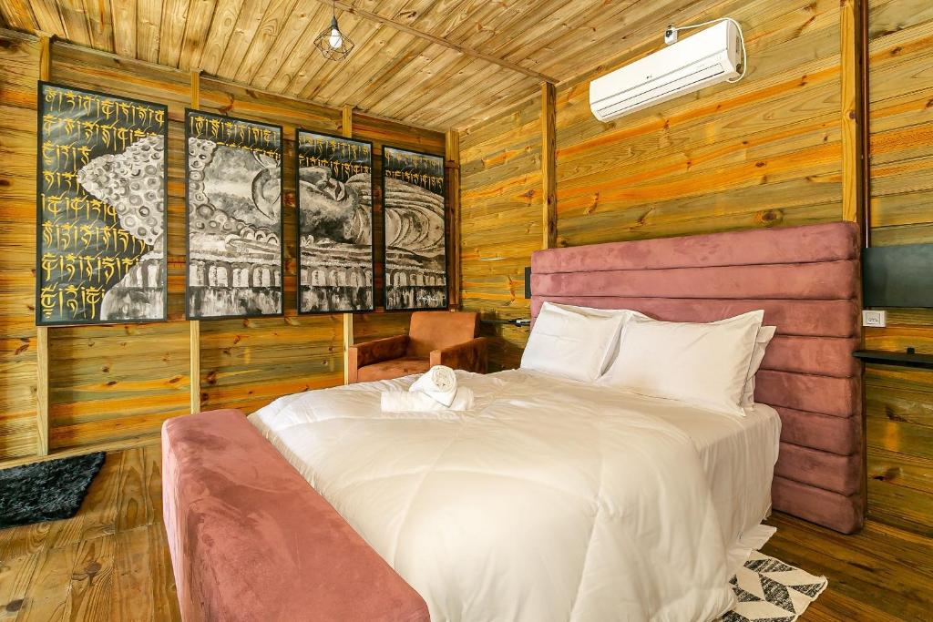 1 dormitorio con 1 cama en una habitación con paredes de madera en Chalé Rústico com Jacuzzi em Jurerê MAV011, en Florianópolis