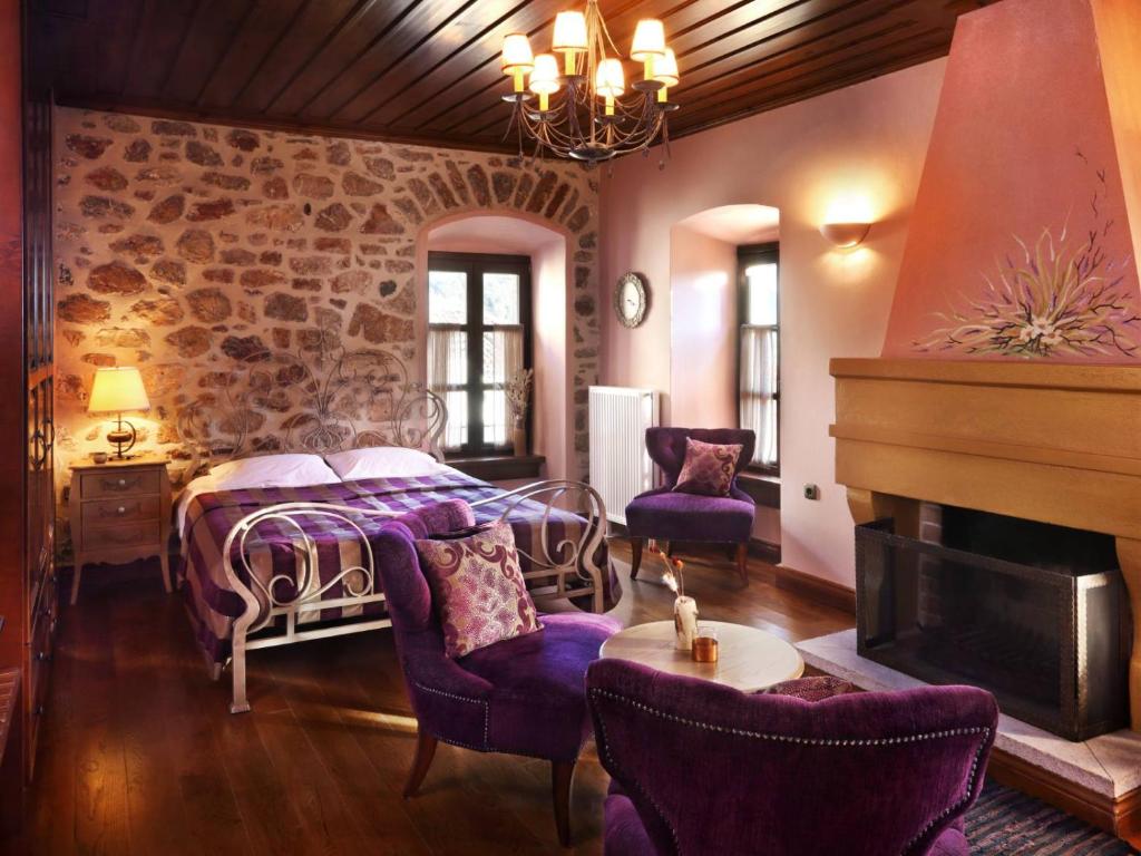 a bedroom with a bed and a fireplace at Lousiou Nymphes escape suites in Dhimitsana