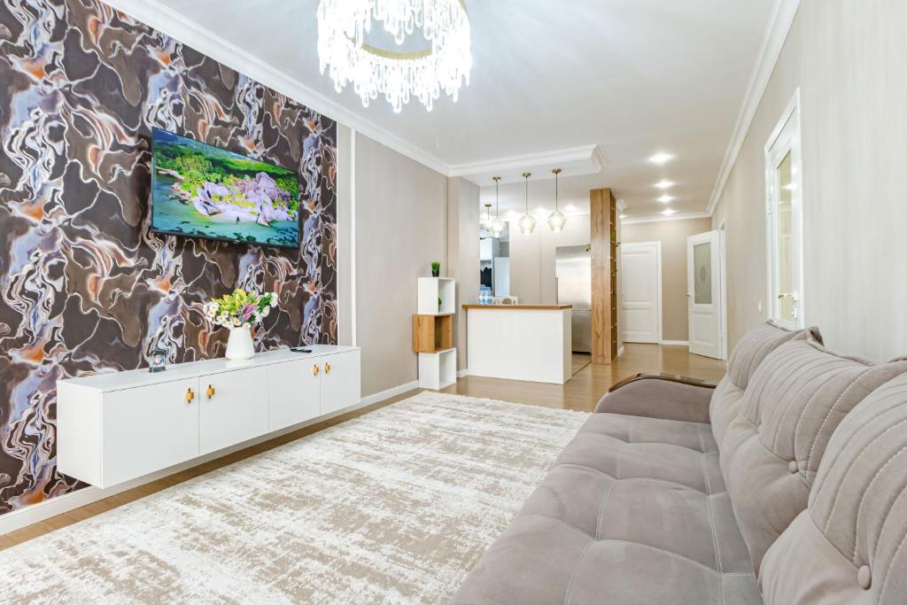 uma sala de estar com um sofá e um quadro na parede em Amor de Astaná, ЖК Симфония, 3 комнатная em Astana