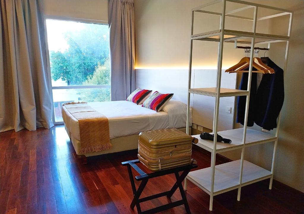 una camera con letto e libreria di Roomie Salta by DOT Suites a Salta