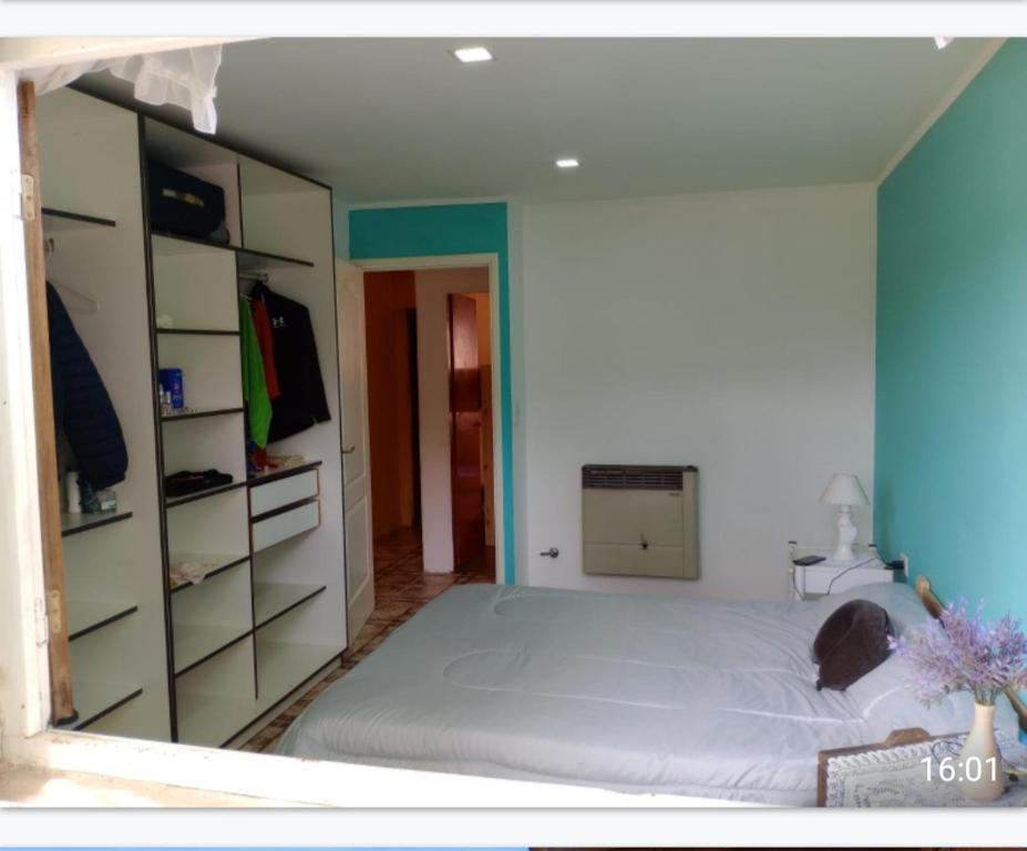 a bedroom with a large white bed and shelves at Casa por dia muy cómoda con garaje y buena atención. in Dolores