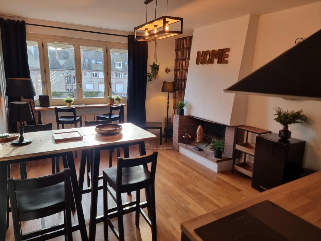uma sala de estar com uma mesa e cadeiras e uma lareira em LE CONCORDE em Gien