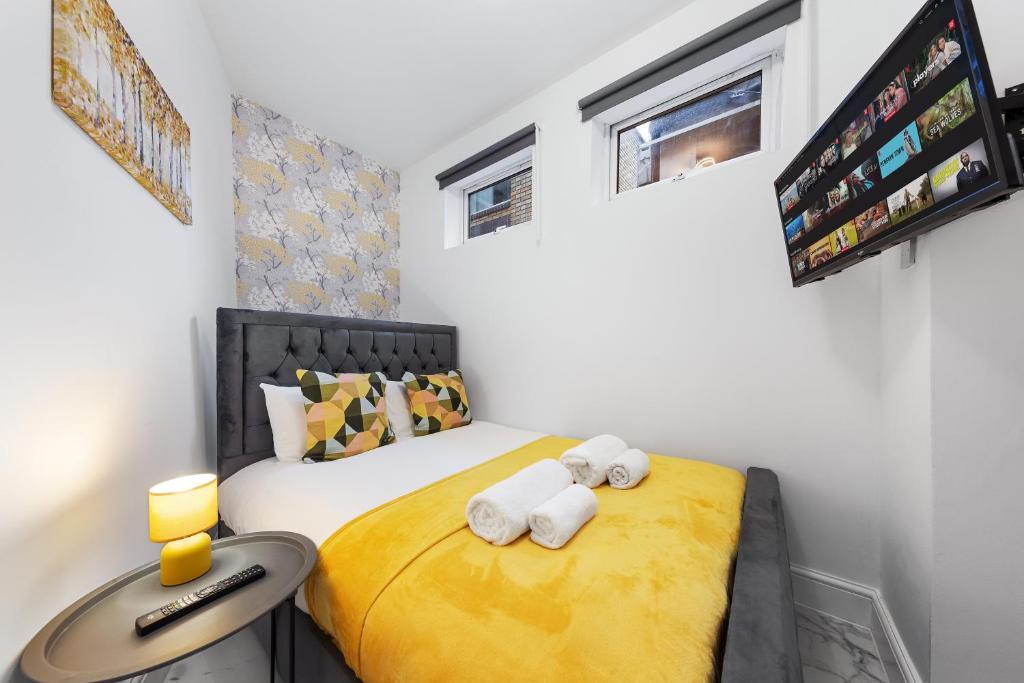 a bedroom with a bed with two towels at Serviced Modern Studio Flat - Sleeps 2 - Good Links to King Cross, Euston, Finchley Road Station - NW3 London in London