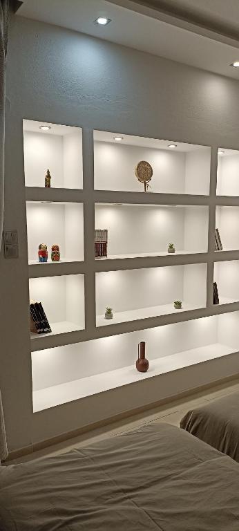 a bedroom with white shelves on the wall at Foivos Apartment in Komotini
