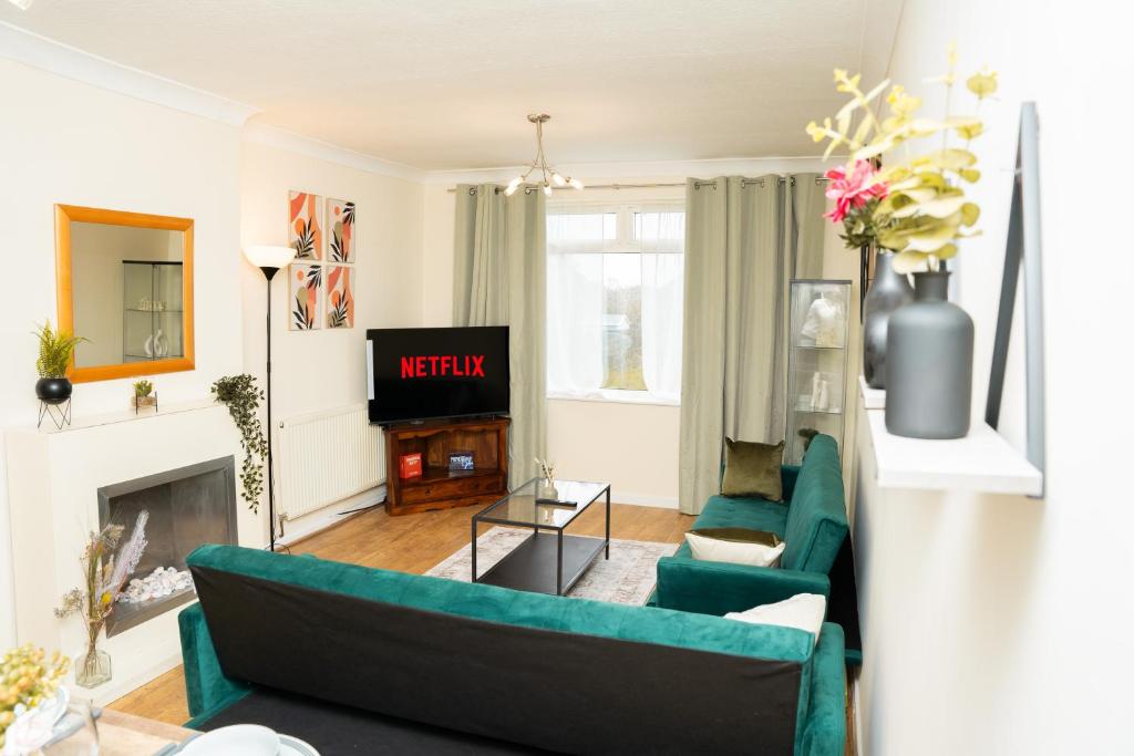 uma sala de estar com um sofá verde e uma televisão em Contemporary Comfort Trendy Hideaway em Robin Hood