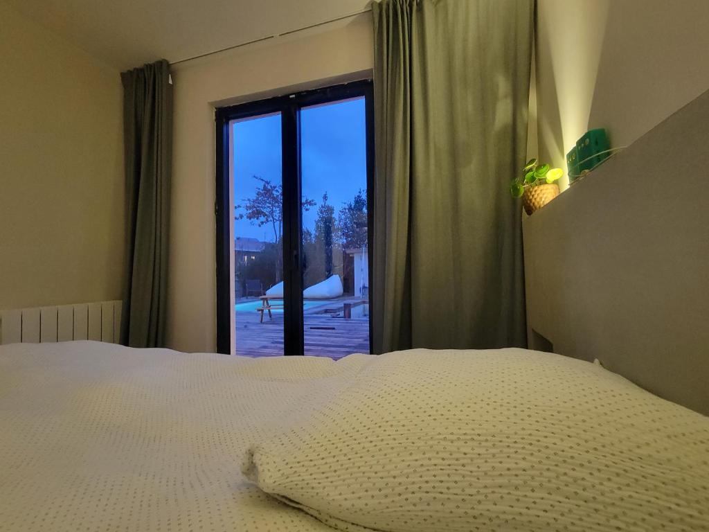 une chambre avec un lit et une grande fenêtre dans l'établissement Maison familiale avec piscine, à Tresses