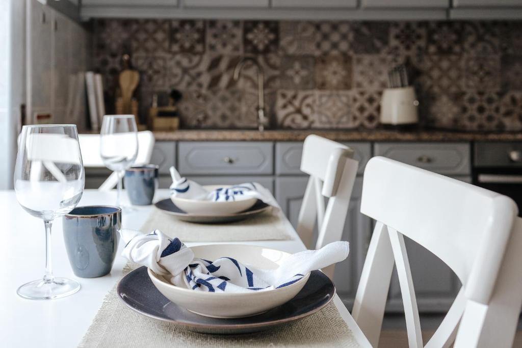 una cocina con una mesa con platos y copas de vino en Casa da Sereia, en Leiria