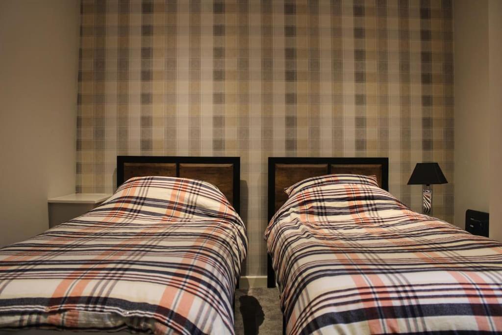 two beds sitting next to each other in a bedroom at Railway House in Glossop