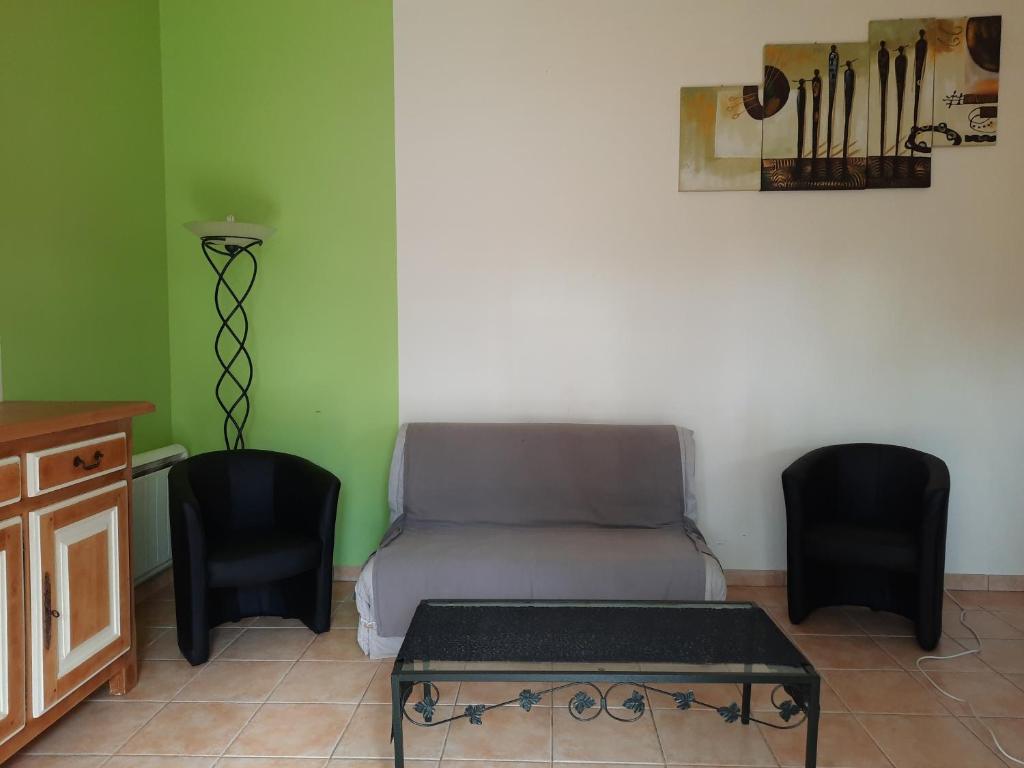 Ce lit se trouve dans une chambre avec 2 chaises et une table. dans l'établissement HERMITAGE, à Anzex